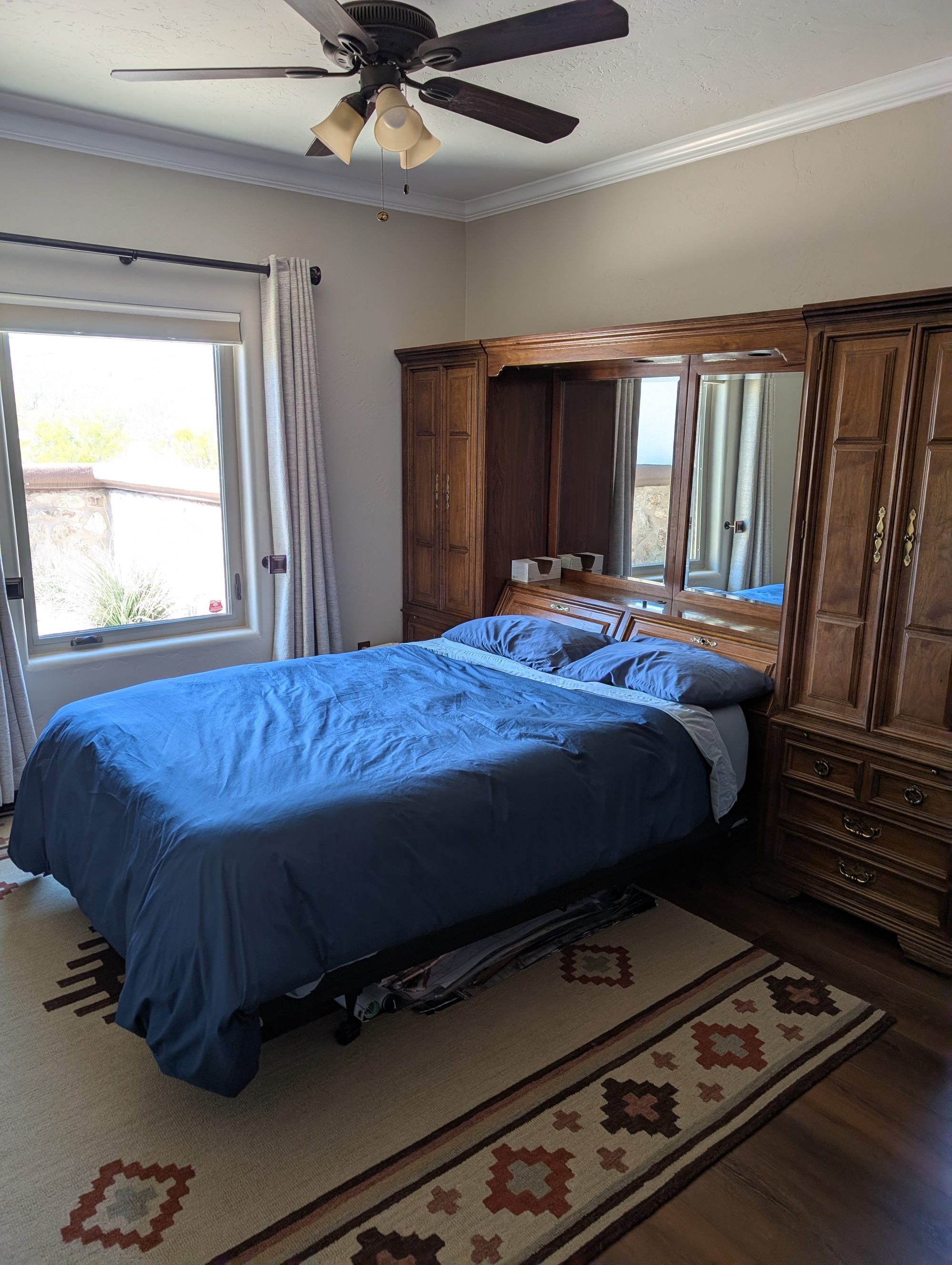 Bedroom with queen bed, mirrored armoire, and hardwood floors