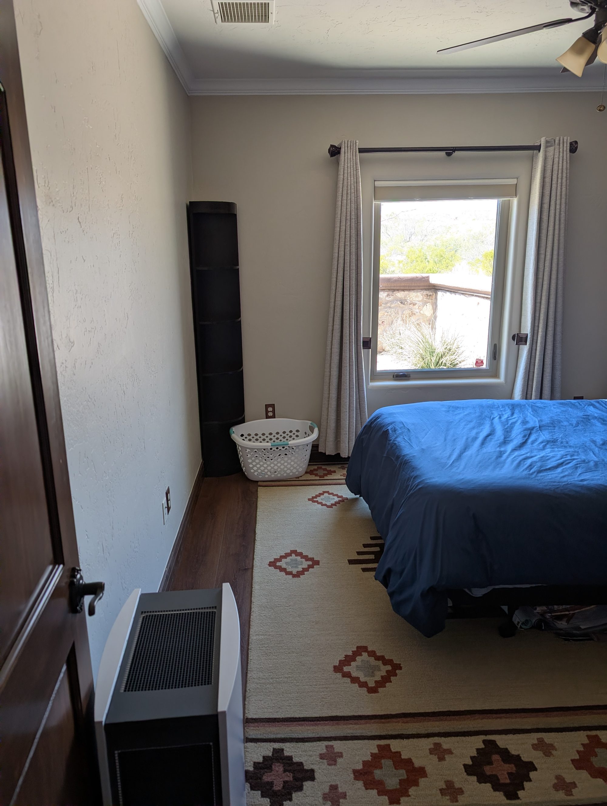 Bedroom from doorway showing dresser, window, and ceiling fan