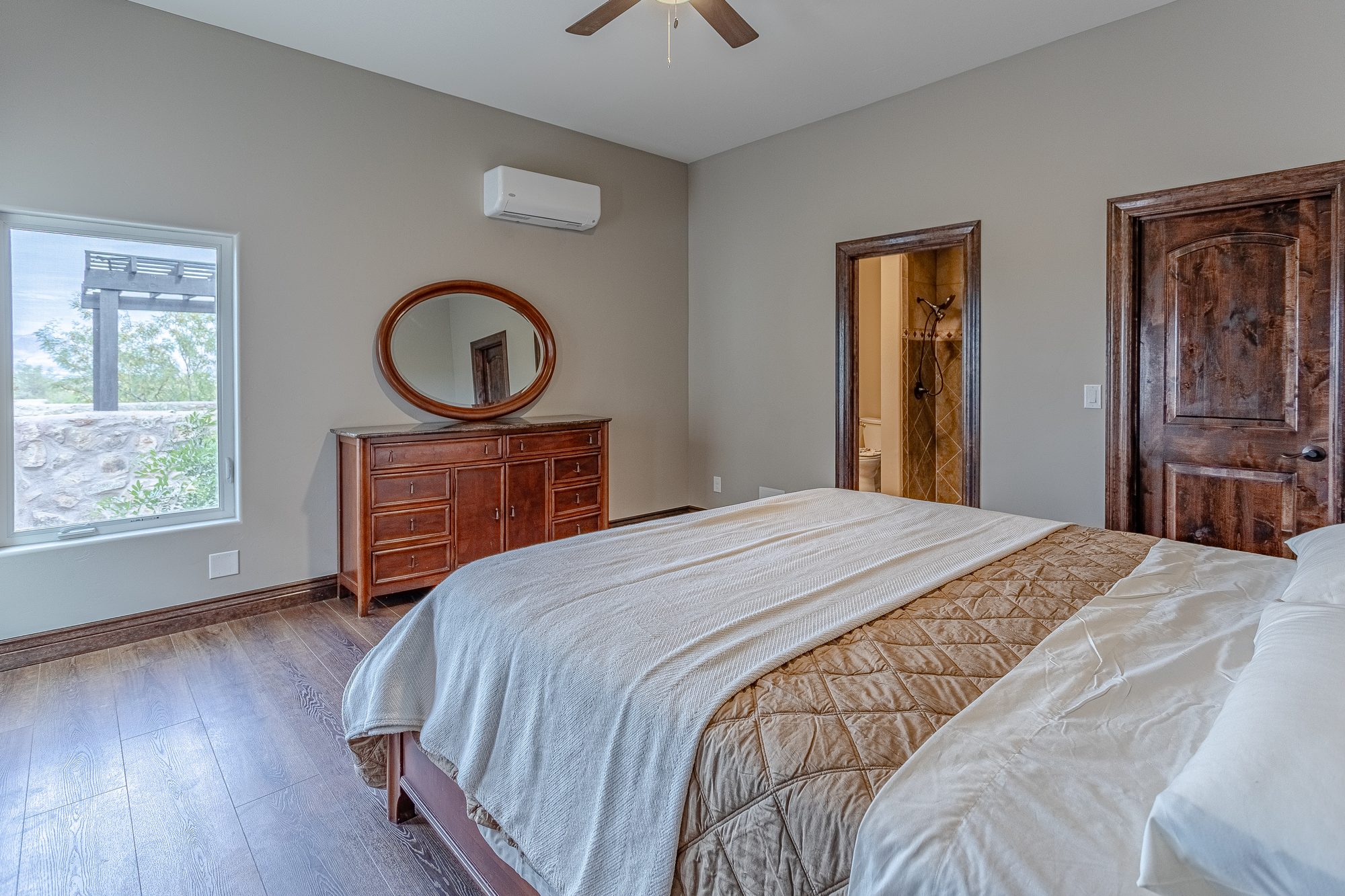Casita bedroom with California King bed, dresser, and window blinds